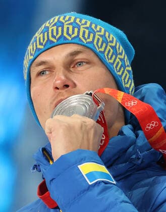 ZHANGJIAKOU, CHINA - FEBRUARY 17, 2022: Silver medallist Oleksandr Abramenko of Ukraine bites his medal during the victory ceremony for the men s freestyle skiing aerials, at the Medal Plaza, at the 2022 Winter Olympic Games, Olympische Spiele, Olympia, OS Stanislav Krasilnikov TASS  TS123D42
