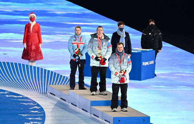 (220220) -- BEIJING, Feb. 20, 2022 -- Gold medalist Alexander Bolshunov (front C) , silver medalist Ivan Yakimushkin (front R) of ROC and bronze medalist Simen Hegstad Krueger (front L) of Norway attend the awarding ceremony of cross-country skiing men s 50km mass start free during the closing ceremony of the Beijing 2022 Olympic Winter games, Winterspiele,Spiele, Summer games at the National Stadium in Beijing, capital of China, Feb. 20, 2022. The men s 50km cross-country mass start race was shortened to 30km due to high winds at the National Cross-Country Skiing Centre. ) (BEIJING2022)CHINA-BEIJING-OLYMPIC WINTER GAMES-CLOSING CEREMONY (CN) LixYibo 