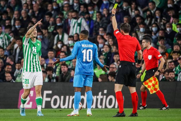 SEVILLE, SPAIN â€“ FEBRUARY 24, 2022: Zenit St Petersburg s Malcom (C) looks on as Betis s Guido Rodriguez (L) is shown a yellow card in the second leg of a UEFA Europa League playoff fooball match between Betis and Zenit St Petersburg at Benito Villamarin Stadium. Alexander Demianchuk TASS  TS1254CB