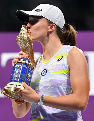 (220227) -- DOHA, Feb. 27, 2022 -- Iga Swiatek of Poland kisses her trophy during the award ceremony of WTA, Tennis Damen Qatar Open tennis tournament at the Khalifa International Tennis Complex in Doha, capital of Qatar, Feb. 26, 2022. (Photo by Nikku Xinhua) (SP)QATAR-DOHA-TENNIS-WTA-FINAL yangyuanyong 