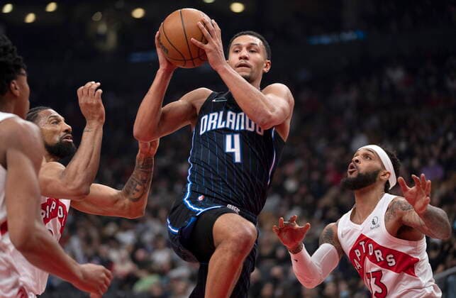 March 4, 2022, Toronto, on, Canada: Orlando Magic guard Jalen Suggs (4) drives between Toronto Raptors guard Gary Trent Jr. (33) and center Khem Birch (24) during first half NBA, Basketball Herren, USA action in Toronto on Friday March 4, 2022. Canada News - March 4, 2022  - ZUMAc35_ 20220304_zaf_c35_040 Copyright: xFrankxGunnx