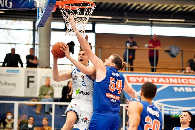 Basketball, 1 Bundesliga, season 2021 2022, catch-up game 15 matchday, SYNTAINICS MBC Mitteldeutscher Basketball Club Weissenfels vs Fraport Skyliners Frankfurt Main 13 03 2022 Duel for the ball between Lorenz Brenneke Forward Skyliners Frankfurt, back number 21 left and John Bryant Center Weissenfels, back number 54 right under the basket during the game Weißenfels vs Fraport Skyliners Frankfurt 13 03 2022 Weißenfels Sachsen Anhalt Germany Stadthalle Weißenfels