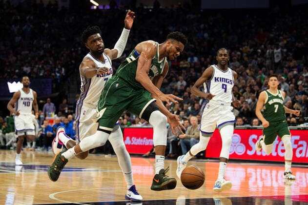 March 16, 2022, Sacramento, CA, USA: Sacramento Kings forward Chimezie Metu (7) fouls Milwaukee Bucks forward Giannis Antetokounmpo (34) during a game at the Golden 1 Center in Sacramento, Wednesday, March 16, 2022. Sacramento USA - ZUMAj89_ 20220316_zaf_j89_011 Copyright: xPaulxKitagakixJr.x