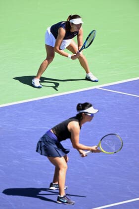 INDIAN WELLS, CA - MARCH 19: Zhaoxuan Yang of China waits for a serve at the baseline with her doubles partner Yifan Xu of China near the net during a doubles finals tennis match at the BNP Paribas Open played on March 19, 2022 at the Indian Wells Tennis Garden in Indian Wells, CA. (Photo by John Cordes Icon Sportswire) TENNIS: MAR 19 BNP Paribas Open Icon506220319027
