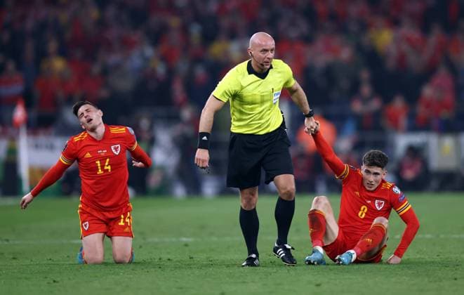 Sport Themen der Woche KW12 Sport Bilder des Tages Cardiff, Wales, 24th March 2022. Referee Szymon Marciniak helps up Harry Wilson of Wales during the FIFA World Cup, WM, Weltmeisterschaft, Fussball 2023 Qualifying - European match at the Cardiff City Stadium, Cardiff. Picture credit should read: Darren Staples Sportimage EDITORIAL USE ONLY. No use with unauthorised audio, video, data, fixture lists, club league logos or live services. Online in-match use limited to 120 images, no video emulation. No use in betting, games or single club league player publications. SPI-1605-0058