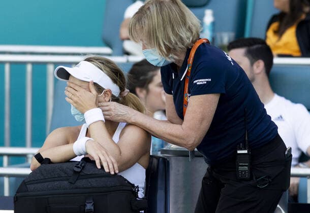 Danielle Collins from the USA wipes away tears as she has her neck worked on by a trainer during a medical time out at the Miami Open in the Hard Rock Stadium in Miami Gardens, Florida, on Saturday, March 26, 2022. Collins defeated Zvonareva 6-1, 6-4.  MIA20220326120 GARYxIxROTHSTEIN