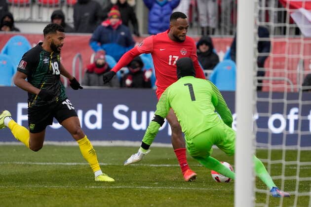March 27, 2022, TORONTO, ON, CANADA: Canada s Cyle Larin moves in on Jamaica keeper Andre Blake as Adrian Mariappa (left) defends during second half CONCACAF World Cup soccer qualifying action in Toronto on Sunday, March 27, 2022. Canada News - March 27, 2022  - ZUMAc35_ 20220327_zaf_c35_107 Copyright: xFrankxGunnx