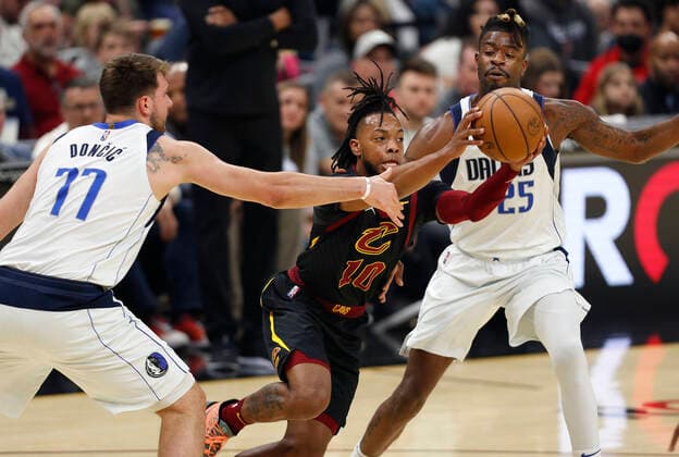 Cleveland Cavaliers guard Darius Garland (C) passes the ball as he is defended by Dallas Mavericks guard Luka Doncic of Slovenia (L) and Dallas Mavericks guard Reggie Bullock (R) during the first half of the NBA, Basketball Herren, USA game between the Cleveland Cavaliers and the Dallas Mavericks at Rocket Mortgage Fieldhouse in Cleveland, Ohio, USA, 30 March 2022. Dallas Mavericks at Cleveland Cavaliers !ACHTUNG: NUR REDAKTIONELLE NUTZUNG!  Copyright: xDavidxMaxwellx AME7670 20220331-7f4b760ef16ca1b4a87d536b1a05c8e44186d94b