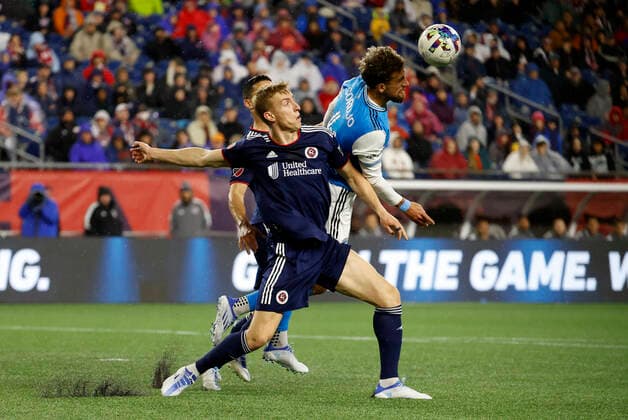 FOXBOROUGH, MA - APRIL 16: Charlotte FC center back Guzm‡n Corujo (4) heads the ball away from New England Revolution forward Adam Buksa (9) during a match between the New England Revolution and Charlotte FC on April16, 2022, at Gillette Stadium in Foxborough, Massachusetts. (Photo by Fred Kfoury III Icon Sportswire) SOCCER: APR 16 MLS, Fussball Herren, USA - Charlotte FC at New England Revolution Icon482220416017