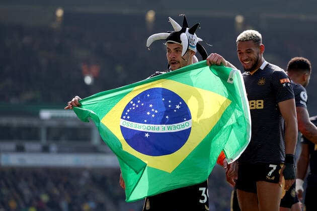 23rd April 2022, Carrow Road, Norwich, Norforlk, England; Premier League football, Norwich versus Newcastle; Bruno Guimaraes of Newcastle United celebrates with a Brazilian flag and Newcastle hat after he scores for 0-3 in the 49th minute  ActionPlus12382307 ShaunxBrooks