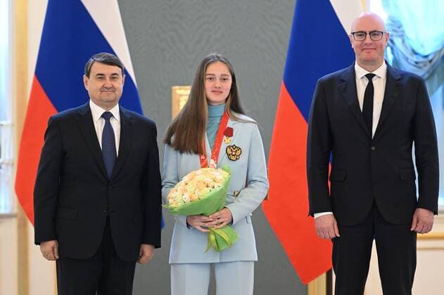 Russia Olympic Athletes Award Ceremony 8175777 26.04.2022 Silver medalist of the Beijing 2022 Winter Olympic Games, Olympische Spiele, Olympia, OS in sky jumping Russian Olympic Committee s Irma Makhinia poses with Russian Deputy Prime Minister Dmitry Chernyshenko, right, and Russia s Presidential Aide Igor Levitin at the award ceremony of her medal of the Order of Merit for the Fatherland, 1st degree, in the Kremlin, Moscow, Russia. Ramil Sitdikov Sputnik Moscow Russia  Copyright: xRamilxSitdikovx
