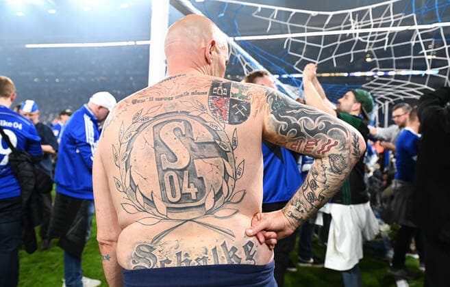 Football, 2 Bundesliga, Germany, Men, Season 2021 2022, 1 Matchday, VELTINS Arena Gelsenkirchen FC Schalke 04 blue FC St Pauli white 3 2 A Schalke fan with huge S04 tattoo on his back Fan, Fans, Fan culture, Enthusiasm, Tattoo, Cheer, Joy, Action DFB DFL REGULATES PROHIBIT ANY USE OF PHOTOGRAPHS AS IMAGE SEQUENCES AND OR QUASI VIDEO