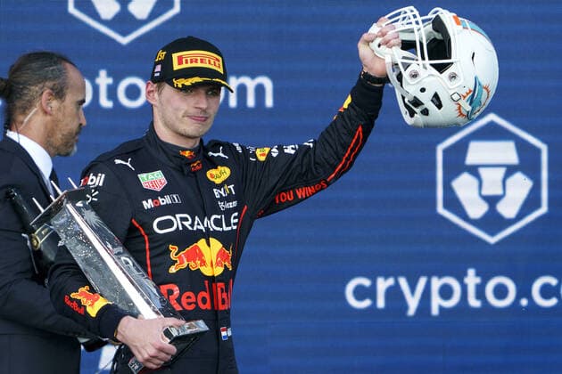 Dutch Formula One driver Max Verstappen of Red Bull Racing holds a Miami Dolphins helmet signed by Dan Marino and the first place trophy during the podium ceremony after the Formula One Grand Prix? of Miami at the Miami International Autodrome in Miami Gardens, Florida, on Sunday, May 8, 2022.  FLA20220508151 GREGxNASH