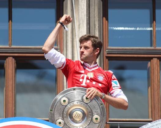 Munich, Germany 15 May 2022 football, men, season 2021 2022, FC Bayern Munich, championship celebration at Marienplatz, city hall Thomas Müller Mueller FC Bayern Munich with the championship trophy and fist, pulls up his arm