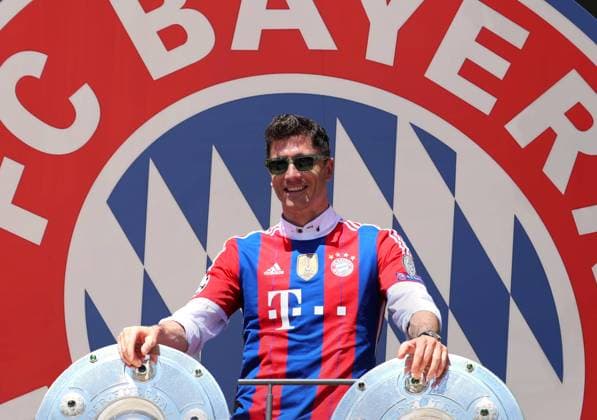 Munich, Germany 15 May 2022 football, men, season 2021 2022, FC Bayern Munich, Robert Lewandowski Robert Lewandowski FC Bayern Munich in a photo montage, as a symbol image, he stays or he goes In the background the logo, coat of arms of the club