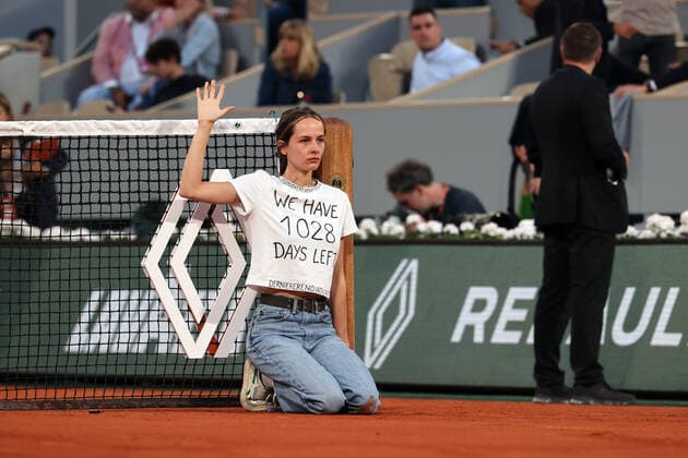 A climate activity is tied to the net during the semi-final match between Marin Cilic of Croatia and Norway s Casper Ruud s at the French Tennis Open in Roland Garros near Paris, France, on Friday, June 3, 2022. The 22-year-old woman who wore a T-shirt that read We have 1028 days left, pushing the world to act on climate change, was removed from the court by security.  PAR20220603161 MAYAxVIDON-WHITE