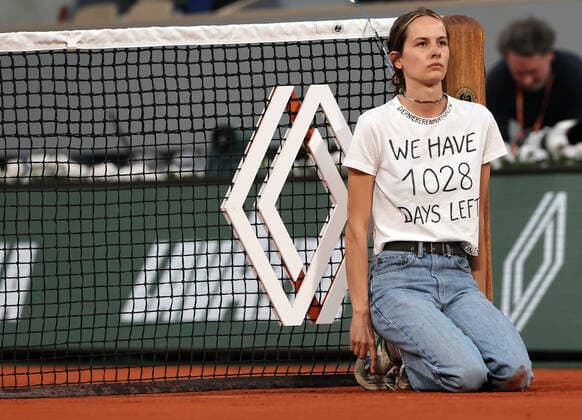 A climate activity is tied to the net during the semi-final match between Marin Cilic of Croatia and Norway s Casper Ruud s at the French Tennis Open in Roland Garros near Paris, France, on Friday, June 3, 2022. The 22-year-old woman who wore a T-shirt that read We have 1028 days left, pushing the world to act on climate change, was removed from the court by security.  PAR20220603158 MAYAxVIDON-WHITE