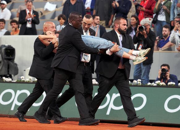 A climate activity is removed from the central court by security after she tied herself to the net during the semi-final match between Marin Cilic of Croatia and Norway s Casper Ruud s at the French Tennis Open in Roland Garros near Paris, France, on Friday, June 3, 2022. The 22-year-old woman wore a T-shirt that read We have 1028 days left, pushing the world to act on climate change.  PAR20220603162 MAYAxVIDON-WHITE