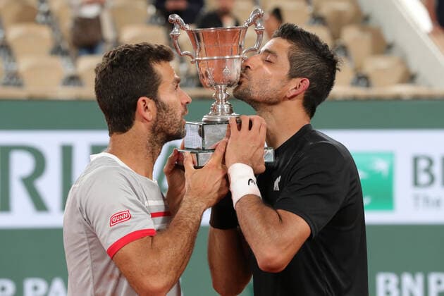 4th June 2022; Roland Garros, Paris, France: French Open Tennis tournament, mens doubles final; Marcelo Arevalo (ELS) and Jean-Julien Rojer (NED) kiss the winners trophy of the Men s Doubles after beating Ivan Dodig (CRO)and Austin Krajicek (USA)  ActionPlus12397004 JonxBromley