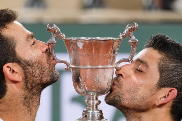 (220605) -- PARIS, June 5, 2022 -- Marcelo Arevalo (R) of Salvador and Jean-julien Rojer of the Netherlands kiss the trophy during the awarding ceremony after the men s doubles final match between Ivan Dodig of Croatia Austin Krajicek of the United States and Marcelo Arevalo of Salvador Jean-julien Rojer of the Netherlands at the French Open tennis tournament at Roland Garros in Paris, France, June 4, 2021. ) (SP)FRANCE-PARIS-TENNIS-ROLAND GARROS-FRENCH OPEN-MEN S DOUBLES-FINAL MengxDingbo 