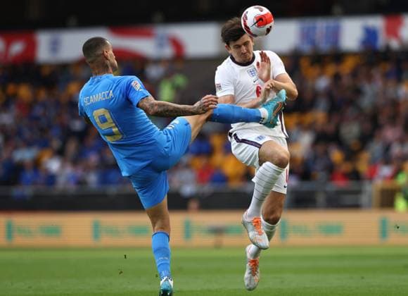 Wolverhampton, England, 11th June 2022. Harry Maguire of England clears under pressure from Gianluca Scamacca of Italy during the UEFA Nations League match at Molineux, Wolverhampton. Picture credit should read: Darren Staples Sportimage EDITORIAL USE ONLY. No use with unauthorised audio, video, data, fixture lists, club league logos or live services. Online in-match use limited to 120 images, no video emulation. No use in betting, games or single club league player publications. SPI-1732-0048