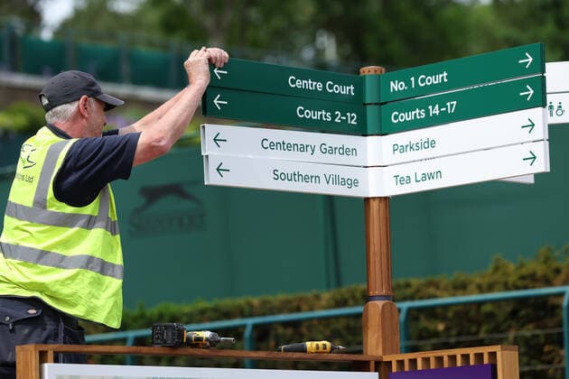 25th June 2022, All England Lawn Tennis and Croquet Club, London, England; Wimbledon Tennis tournament; Ground staff make last minute preparations to signage  ActionPlus12402295 ShaunxBrooks