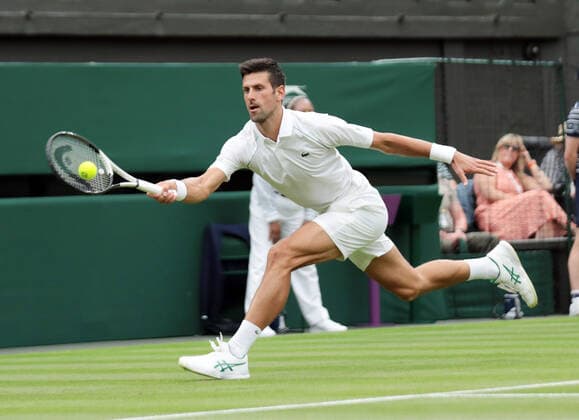 Serbian Novak Djokovic plays a forehand in his match against Korean Soonwoo Kwon in the first round of the 2022 Wimbledon championships in London on June 27, 2022.  LON2022062707 HUGOxPHILPOTT