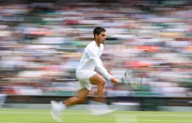(220704) -- LONDON, July 4, 2022 -- Carlos Alcaraz of Spain hits a return during the men s singles fourth round match against Jannik Sinner of Italy at Wimbledon tennis Championship in London, Britain, on July 3, 2022. ) (SP)BRITAIN-LONDON-TENNIS-WIMBLEDON-MEN S SINGLES HanxYan 