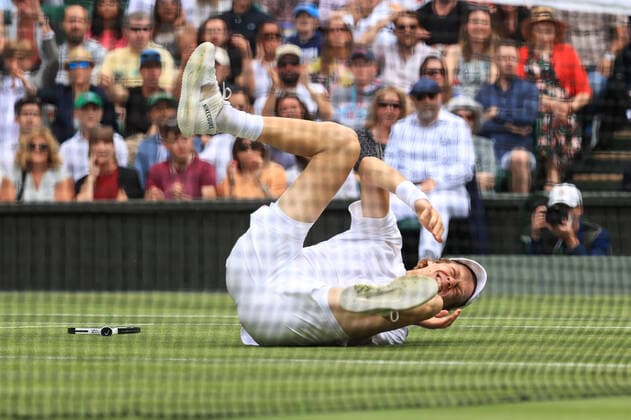 Tennis Wimbledon Tag 9 5. Juli 2022 Tennis Wimbledon Tag 9 Jannik Sinner ITA verrenkt sich vor Schmerzen den Knöchel und rutscht während seines Viertelfinalspiels im Herreneinzel gegen Novak Djokovic SRB aus Foto Simon Stacpoole Offside London UK  Copyright: xSimonxStacpoolexOffside