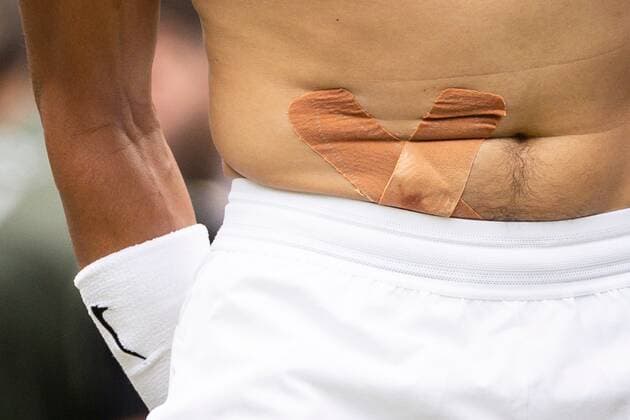 Mandatory Credit: Photo by Ella Ling Shutterstock (13018040ay) Rafael Nadal with tape on a stomach injury during his quarter final match Wimbledon Tennis Championships, Day 10, The All England Lawn Tennis and Croquet Club, London, UK - 06 Jul 2022 Wimbledon Tennis Championships, Day 10, The All England Lawn Tennis and Croquet Club, London, UK - 06 Jul 2022  Copyright: xEllaxLing Shutterstockx 13018040ay