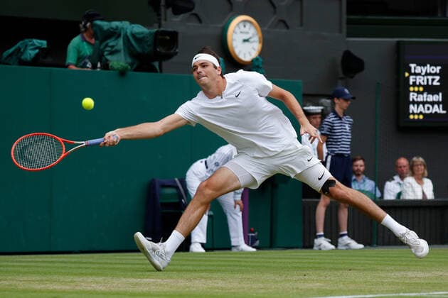 6th July 2022, All England Lawn Tennis and Croquet Club, London, England; Wimbledon Tennis tournament; Taylor Fritz (USA) stretches to play a forehand to Rafael Nadal (ESP)  ActionPlus12405463 JohnxPatrickxFletcher