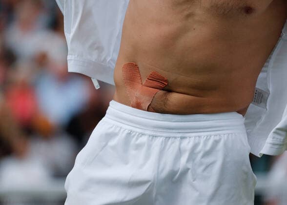 6th July 2022, All England Lawn Tennis and Croquet Club, London, England; Wimbledon Tennis tournament; Rafael Nadal (ESP) with kinesis tape on his stomach before being interviewed after defeating Taylor Fritz (USA) to reach the semi final  ActionPlus12405513 JohnxPatrickxFletcher
