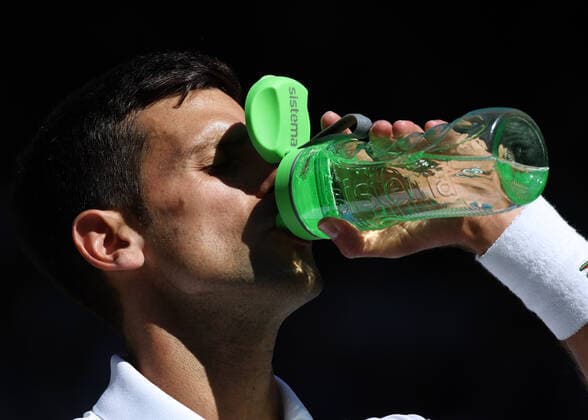 8th July 2022, All England Lawn Tennis and Croquet Club, London, England; Wimbledon Tennis tournament; Novak& xa0;Djokovic (SRB) taking a drink of water during the break in the mens singles semi-final versus Cameron Norrie (GBR)  ActionPlus12406016 JohnxPatrickxFletcher