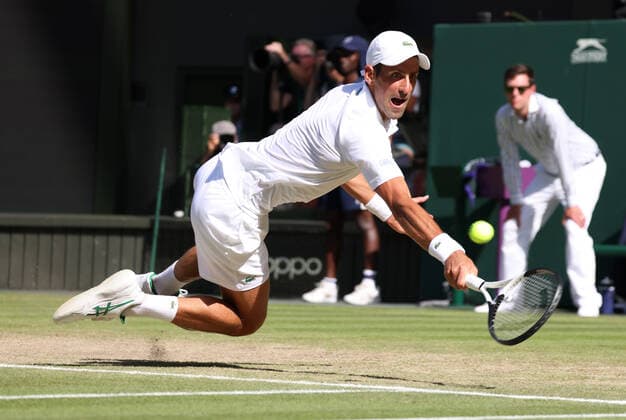Serbian Novak Djokovic plays a backhand in his Semi-Final match against Great Britain s Cameron Norrie on day twelve of the 2022 Wimbledon championships in London on Friday, July 08, 2022. Djokovic won the match 2-6,6-3,6-2,6-4.  LON2022070804 HUGOxPHILPOTT