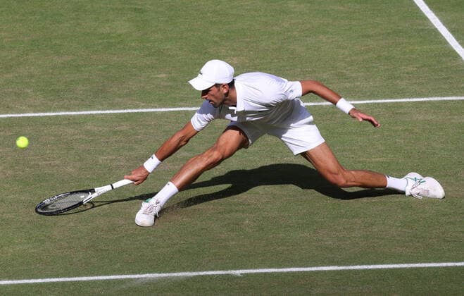 Serbian Novak Djokovic lunges for the ball in the Men s Final match against Australian Nick Kyrgios on day fourteen of the 2022 Wimbledon championships in London on Sunday, July 10, 2022. Djokovic won the match 4-6,6-3,6-4,7-6.  LON2022071011 HUGOxPHILPOTT