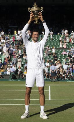 Serbian Novak Djokovic holds the Wimbledon trophy after victory in the Men s Final match against Australian Nick Kyrgios on day fourteen of the 2022 Wimbledon championships in London on Sunday, July 10, 2022. Djokovic won the match 4-6,6-3,6-4,7-6.  LON2022071029 HUGOxPHILPOTT