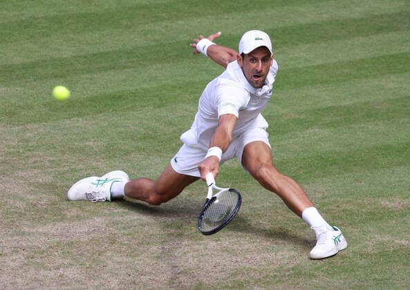 Serbian Novak Djokovic plays a backhand in the Men s Final match against Australian Nick Kyrgios on day fourteen of the 2022 Wimbledon championships in London on Sunday, July 10, 2022. Djokovic won the match 4-6,6-3,6-4,7-6.  LON2022071015 HUGOxPHILPOTT