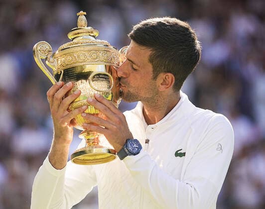 Tennis: Wimbledon championships Novak Djokovic of Serbia kisses the victor s trophy after defeating Nick Kyrgios of Australia in the men s singles final at the Wimbledon tennis championships in London on July 10, 2022. Djokovic won his fourth straight and seventh overall Wimbledon title.  A14AA0001313144P