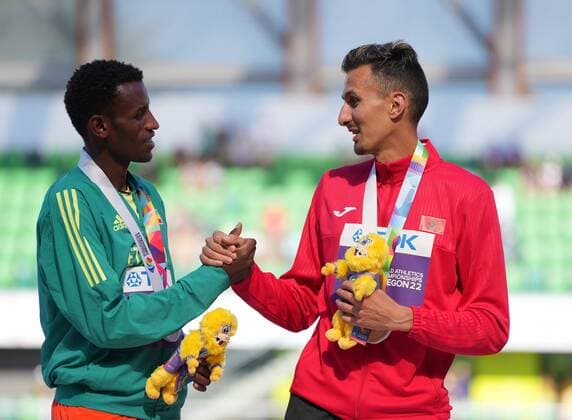 (220720) -- EUGENE, July 20, 2022 -- Gold medalist Soufiane El Bakkali (R) of Morroco shakes hands with silver medalist Lamecha Girma of Ethiopia during the awarding ceremony for men s 3000m steeplechase at the World Athletics Championships Oregon22 in Eugene, Oregon, the United States, July 19, 2022. ) (SP)U.S.-EUGENE-ATHLETICS-WORLD CHAMPIONSHIPS-MEN S 3000M STEEPLECHASE-AWARDING CEREMONY WuxXiaoling 