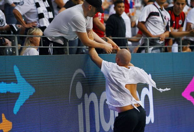 Football 1 Bundesliga Season 2022 2023 1 Matchday Eintracht Frankfurt FC Bayern Muenchen 05 08 2022 An Eintracht Frankfurt Ultra flees after trying to steal a block flag from the St Pauli Ultras at the guest fan block of the arena in Frankfurt, while fleeing he gets help