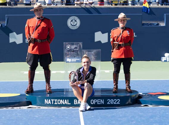 August 14, 2022, Toronto, Ontario, Canada: SIMONA HALEP from Romania holds up her trophy while sitting between two members of the Royal Canadian Mounted Police after she defeated Beatriz Haddad Maia 3-6, 6-2, 3-6 to win the National Bank Open in Toronto Canada. Toronto Canada - ZUMAm215 20220814_zip_m215_012 Copyright: xArlynxMcAdoreyx