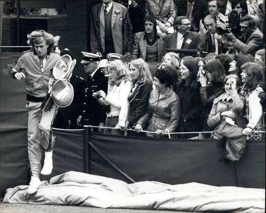 Jun 27, 1974 - London, ENG, United Kingdom - The Swedish tennis star BJORN BORG, left, jumps over a barrier next to adoring fans to enter the court for his Wimbledon match against Australia’s R. Case. Borg defeated Case in their second round matchup on Thursday June 27, 1974. London United Kingdom - ZUMAk09_ 19740627_jes_k09_629 Copyright: xKeystonexPressxAgencyx