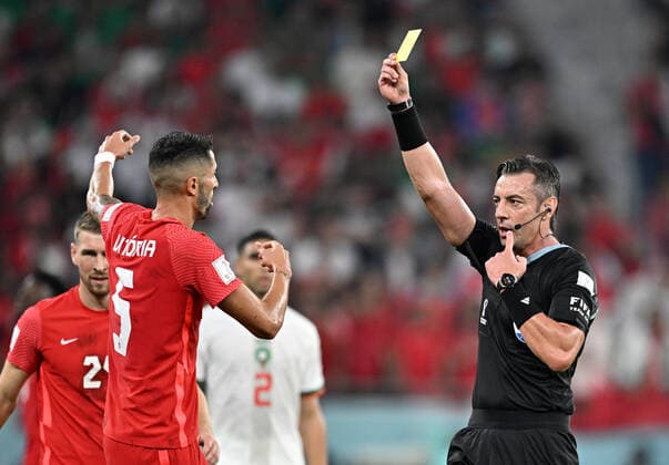 (221201) -- DOHA, Dec. 1, 2022 -- Referee Raphael Claus (R) gives Steven Vitoria (2nd L) of Canada a yellow card during the Group F match between Canada and Morocco at the 2022 FIFA World Cup, WM, Weltmeisterschaft, Fussball at Al Thumama Stadium in Doha, Qatar, Dec. 1, 2022. ) (SP)QATAR-DOHA-2022 WORLD CUP-GROUP F-CAN VS MAR XinxYuewei 