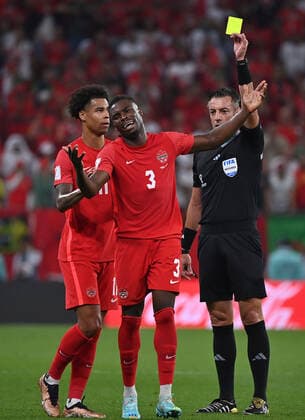 Sport Bilder des Tages (221201) -- DOHA, Dec. 1, 2022 -- Referee Raphael Claus (R) gives Sam Adekugbe (C) of Canada a yellow card during the Group F match between Canada and Morocco at the 2022 FIFA World Cup, WM, Weltmeisterschaft, Fussball at Al Thumama Stadium in Doha, Qatar, Dec. 1, 2022. ) (SP)QATAR-DOHA-2022 WORLD CUP-GROUP F-CAN VS MAR ChenxCheng 