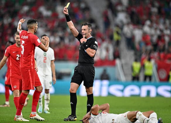 (221201) -- DOHA, Dec. 1, 2022 -- Referee Raphael Claus (R) gives Steven Vitoria (2nd L) of Canada a yellow card during the Group F match between Canada and Morocco at the 2022 FIFA World Cup, WM, Weltmeisterschaft, Fussball at Al Thumama Stadium in Doha, Qatar, Dec. 1, 2022. ) (SP)QATAR-DOHA-2022 WORLD CUP-GROUP F-CAN VS MAR XinxYuewei 