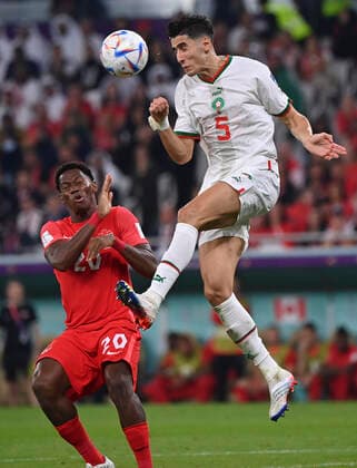 (221201) -- DOHA, Dec. 1, 2022 -- Nayef Aguerd (R) of Morocco and Jonathan David of Canada in action during their Group F match at the 2022 FIFA World Cup, WM, Weltmeisterschaft, Fussball at Al Thumama Stadium in Doha, Qatar, Dec. 1, 2022. ) (SP)QATAR-DOHA-2022 WORLD CUP-GROUP F-CAN VS MAR ChenxCheng 