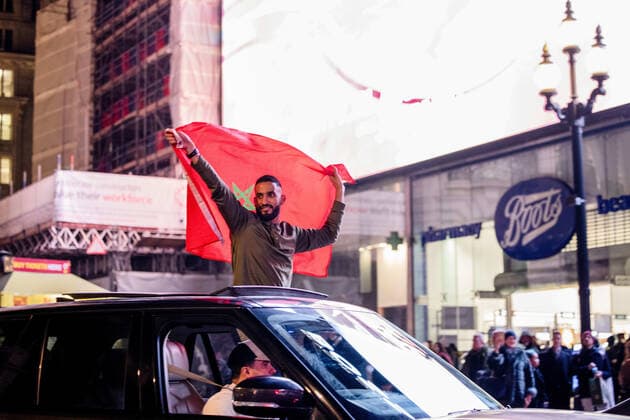 December 10, 2022, London, United Kingdom: A Morocco football supporter is holding a Moroccan flag high from a vehicle to celebrate the winning over Portugal in 2022 FIFA World Cup, WM, Weltmeisterschaft, Fussball Moroccan, other North African and Middle-Eastern who reside in London celebrate in the city of London after Morocco beats Portugal in 2022 FIFA World Cup quarter-final. Morocco is the first African country breaking into semi-final in World Cup in history. London United Kingdom - ZUMAs197 20221210_zaa_s197_308 Copyright: xHestherxNgx