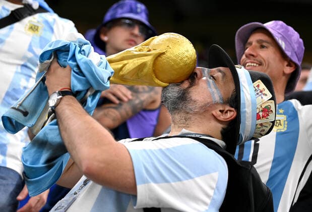 LUSAIL CITY, QATAR - DECEMBER 13: Fans of Argentina celebrates with a Fifa Trophy ,during the FIFA World Cup, WM, Weltmeisterschaft, Fussball Qatar 2022 semi final match between Argentina and Croatia at Lusail Stadium on December 13, 2022 in Lusail City, Qatar. WCS 