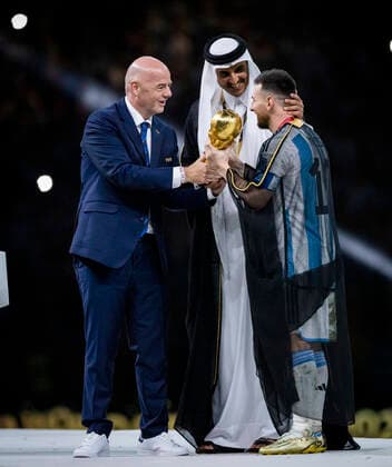 Doha, Qatar 18th Dec, 2022 Lionel Messi of Argentina carries the FIFA World Cup Qatar 2022 Winner s Trophy as Gianni Infantino, President of FIFA, and Sheikh Tamim bin Hamad Al Thani, Emir of Qatar, look on during the FIFA World Cup Qatar 2022 Final match between Argentina France Final match Argentina France World Cup 2022 in Qatar 18 12 2022