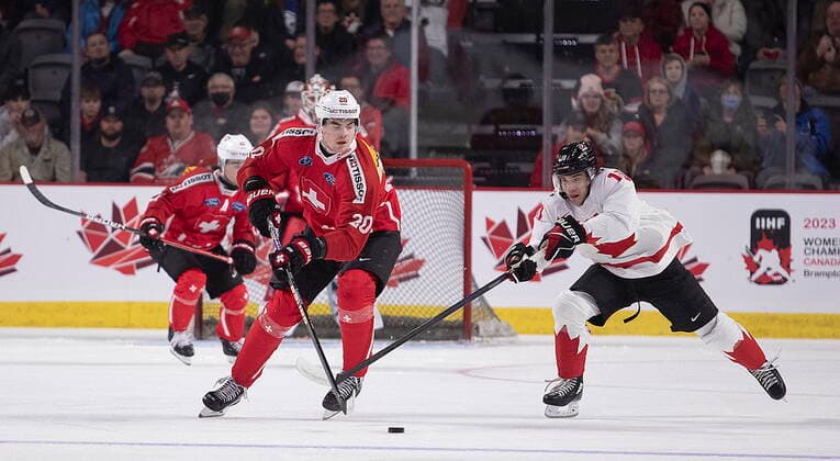 December 19, 2022, Moncton, NB, Canada: Switzerland s Lian Bichsel tries to clear his zone as Canada s Logan Stankoven gives chase during first period IIHF World Junior Hockey Championship pre-tournament hockey action in Moncton, N.B., on Monday, Dec. 19, 2022. Canada News - December 19, 2022  - ZUMAc35_ 20221219_zaf_c35_059 Copyright: xRonxWardx